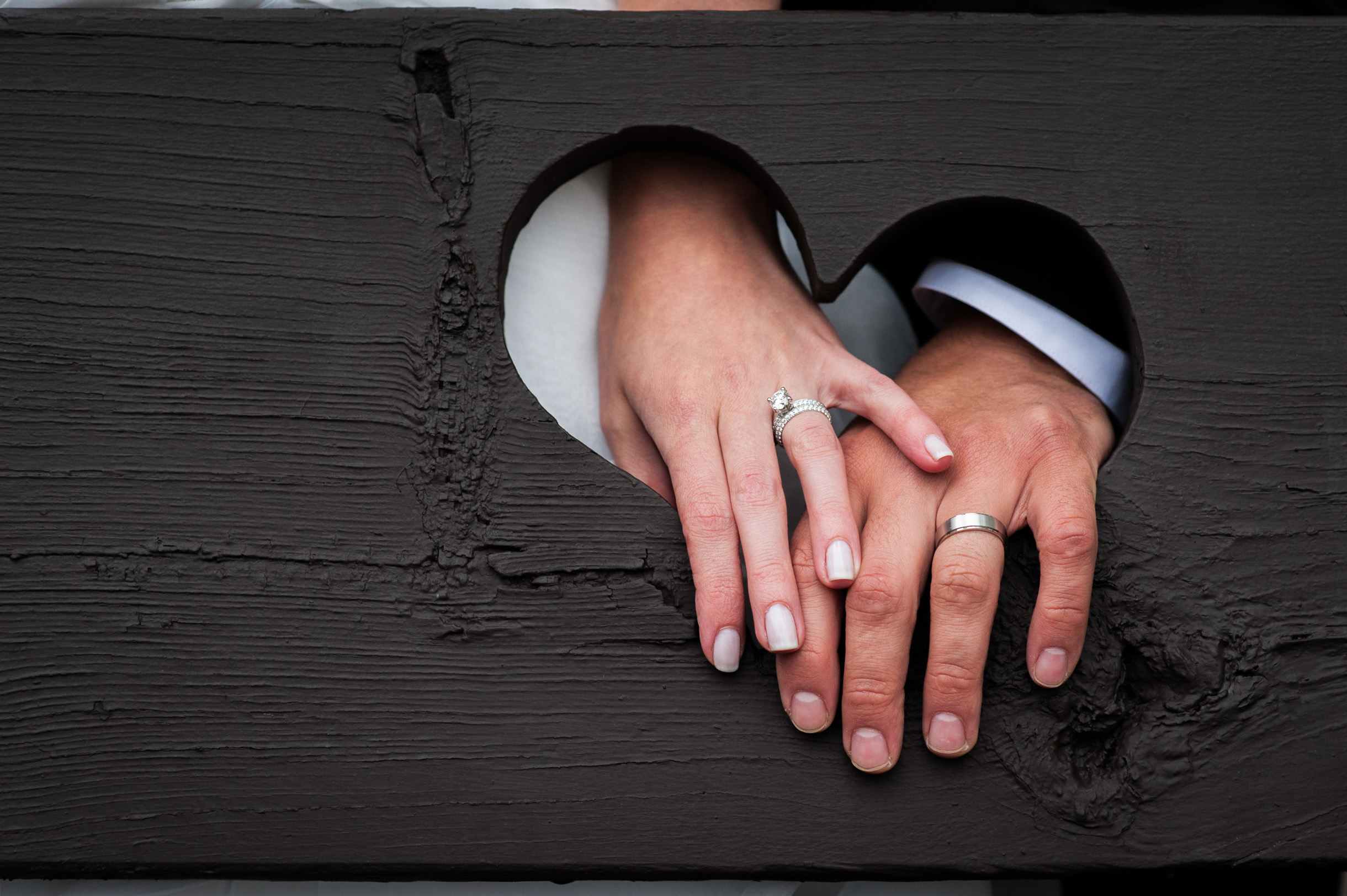 Bride and Grooms hands in heart with wedding rings