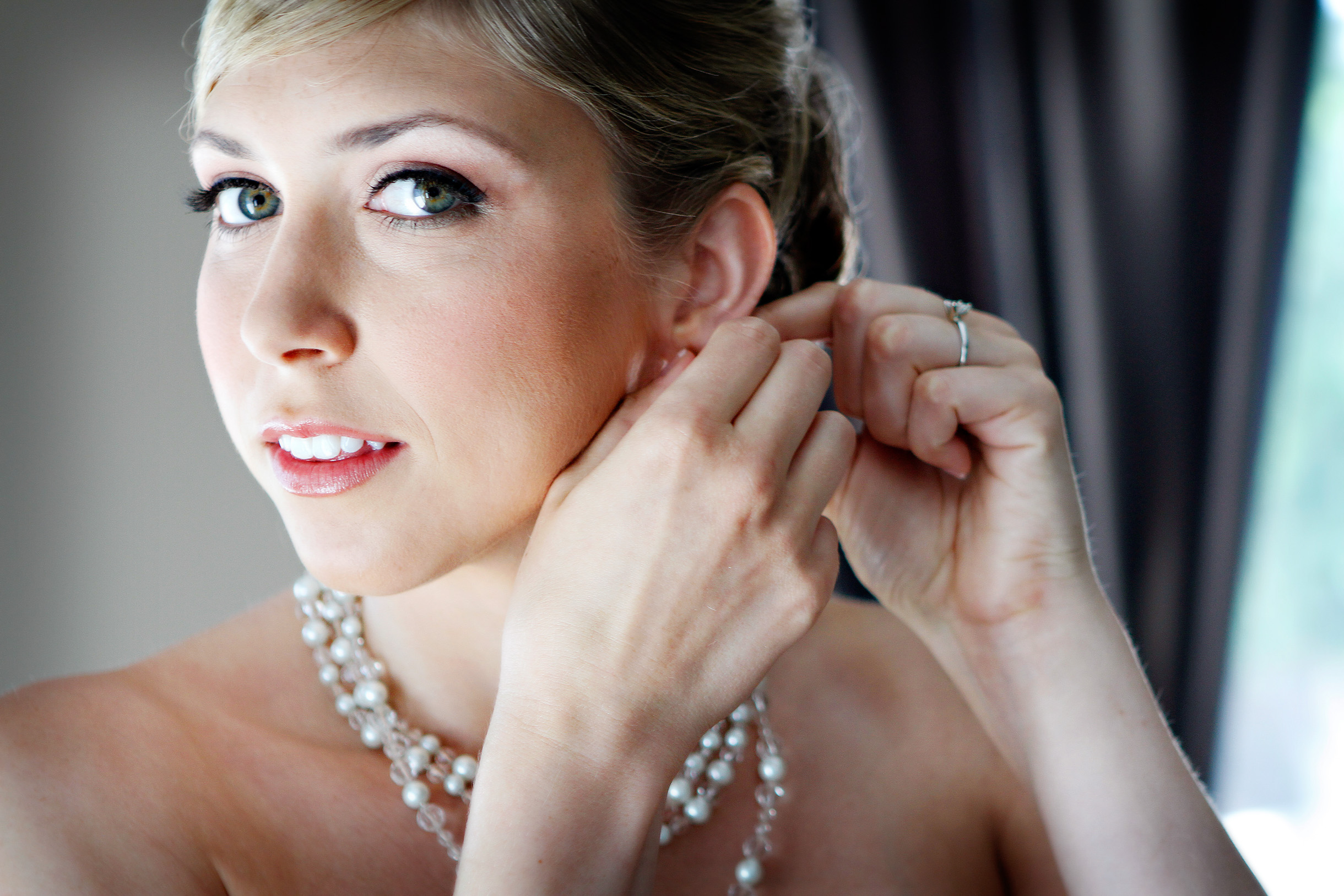 Bride putting on her earring