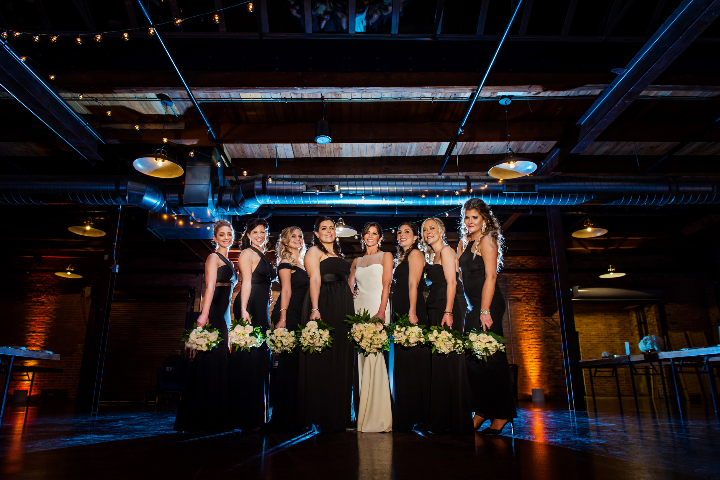 Bridesmaids in blue light holding wedding bouquets