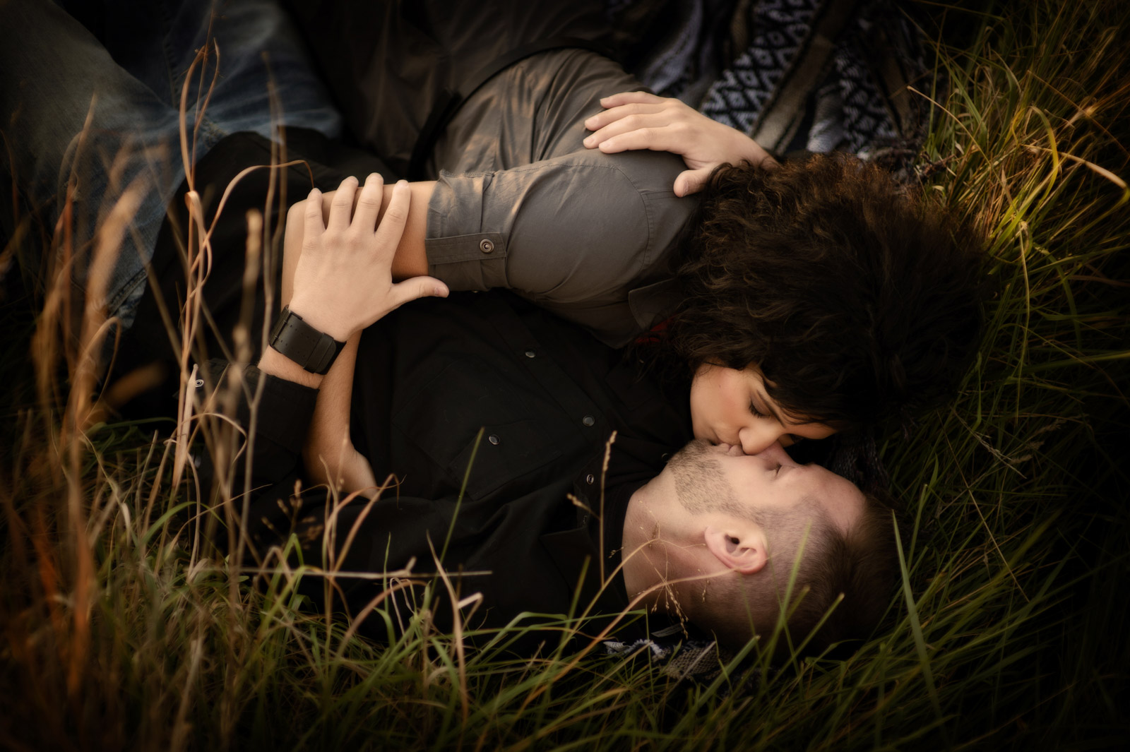 Couple rolling in a grassy field during their engagement session in Chicago
