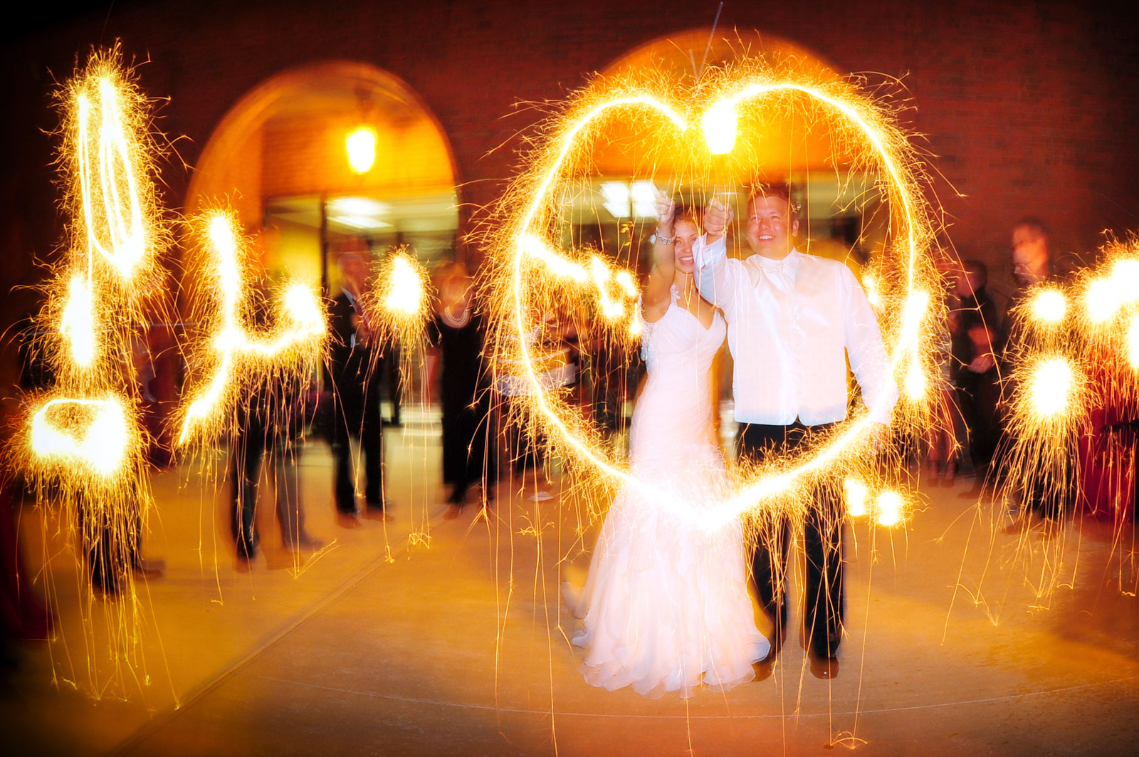 Bride and Groom with wedding sparklers making a heart